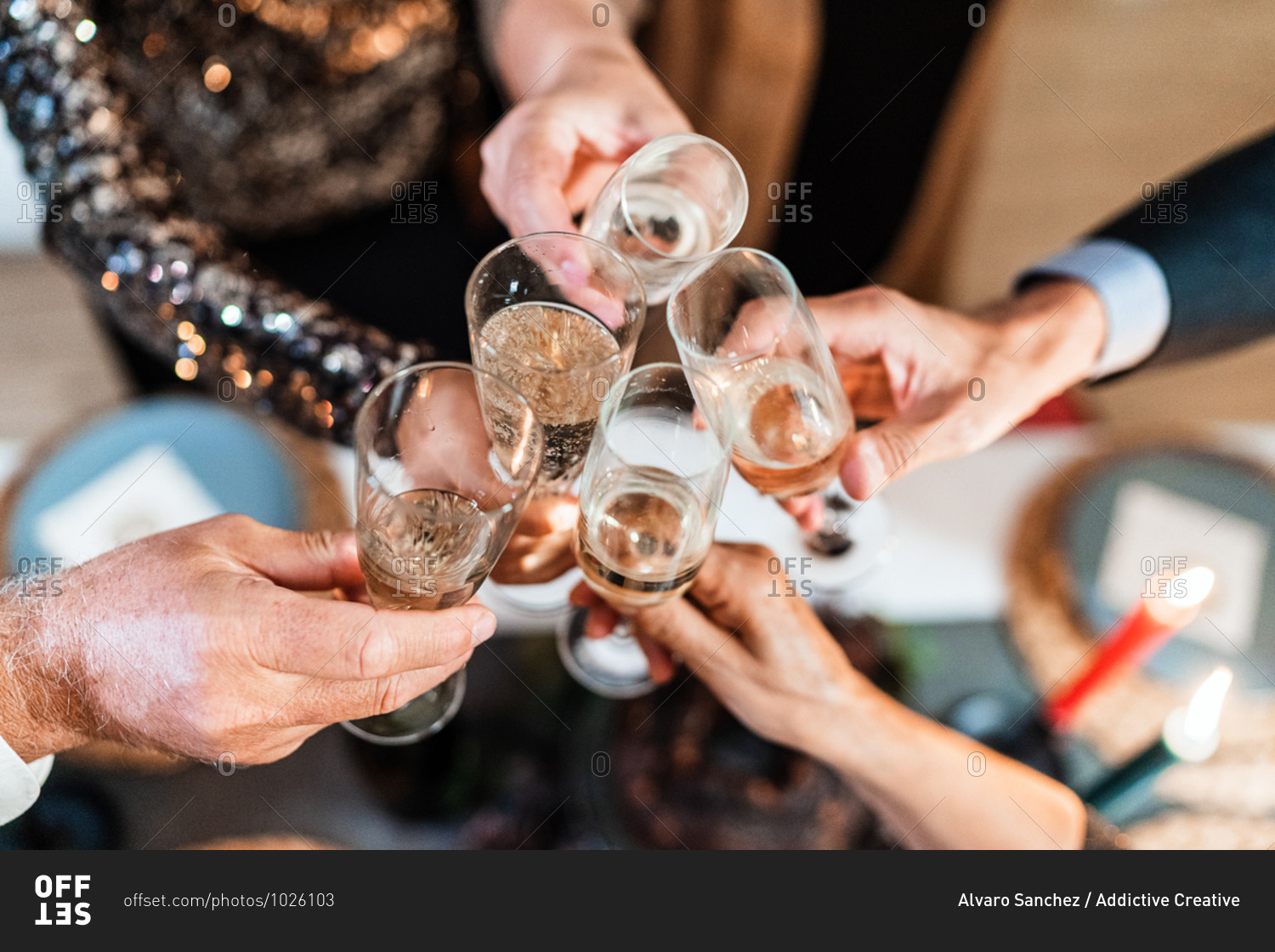 From above of unrecognizable group of people clinking glasses with champagne during Christmas party at home