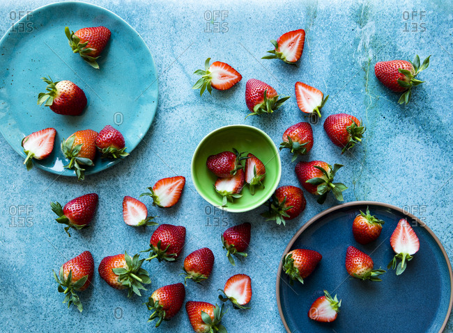 Overhead view of fresh strawberries on blue plates