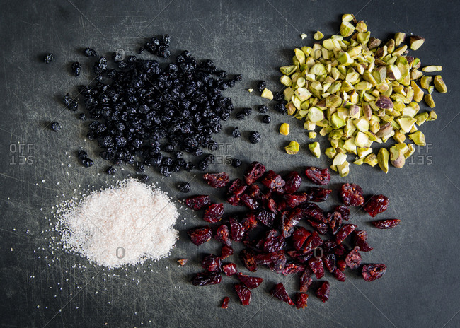 Dried blueberries, cranberries, pistachios and sea salt on gray background