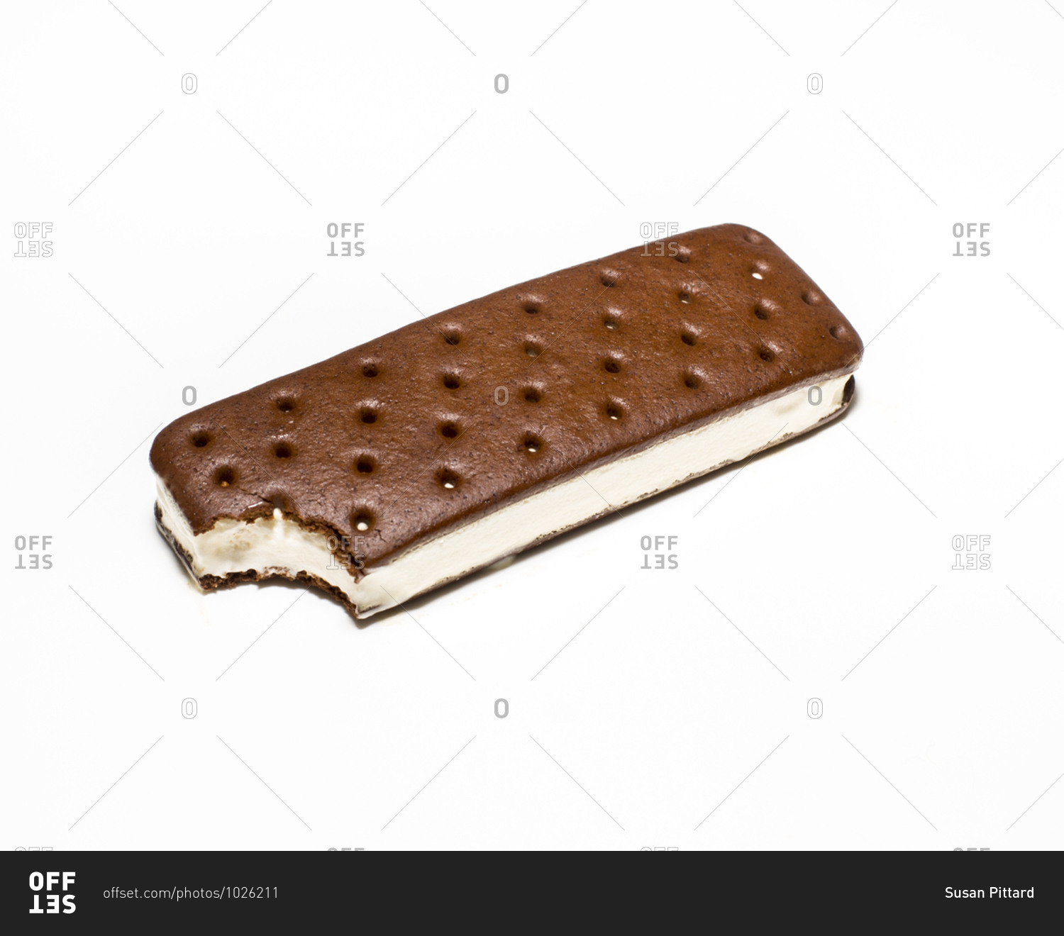 Ice cream sandwich missing a bite on white surface