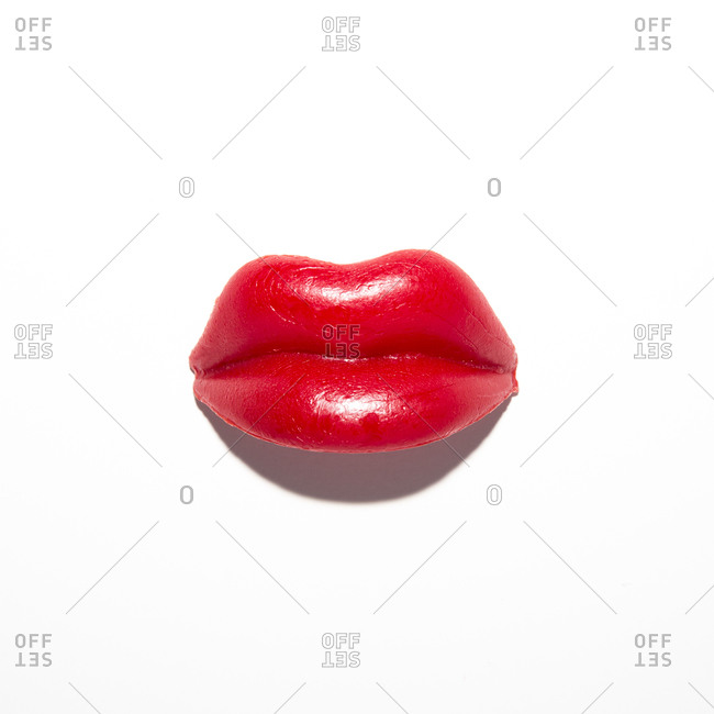 Red wax candy lips on white background