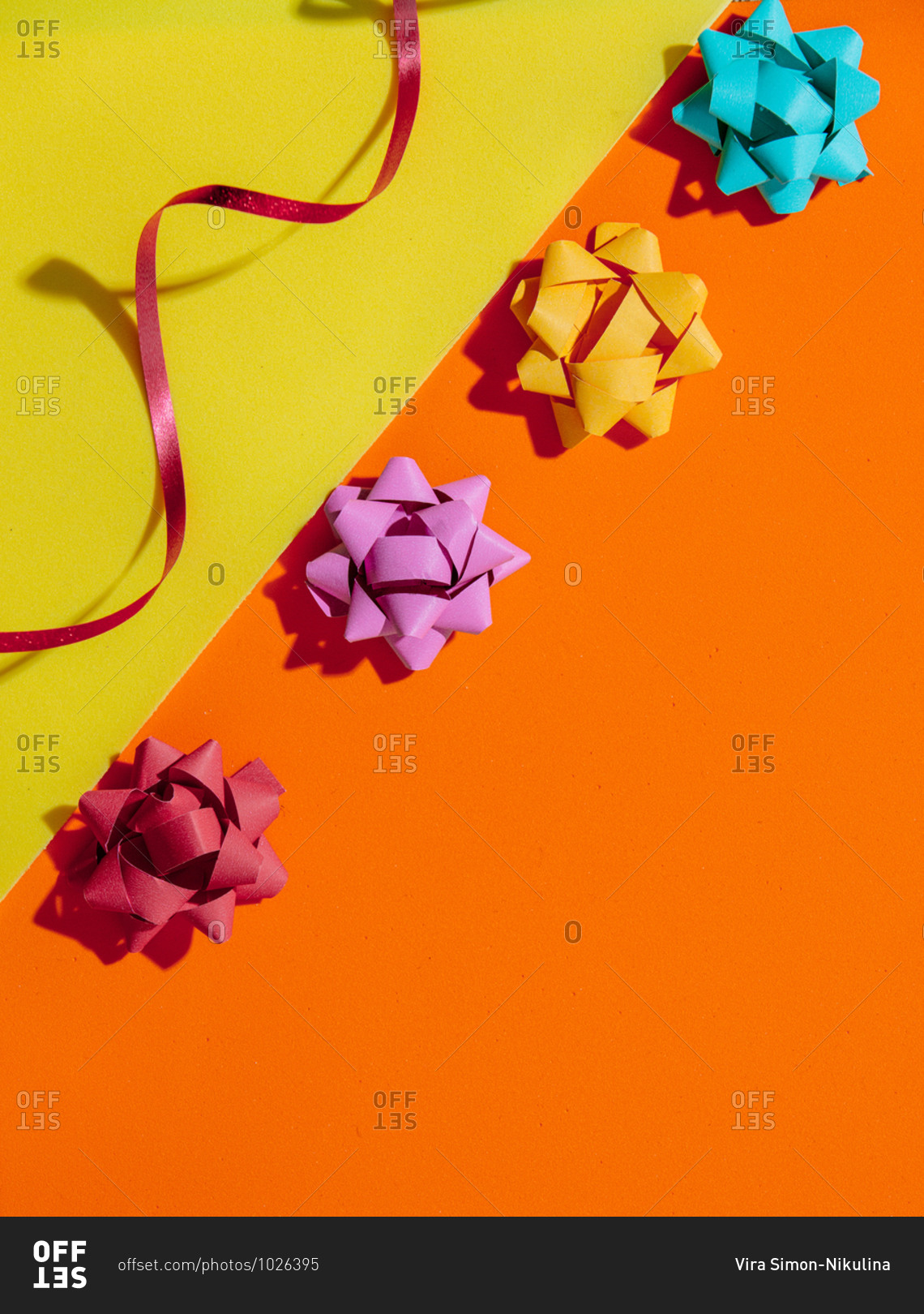 Holiday bows on orange and yellow background viewed from above