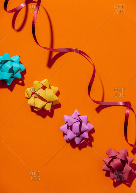 Overhead view of holiday bows on orange background