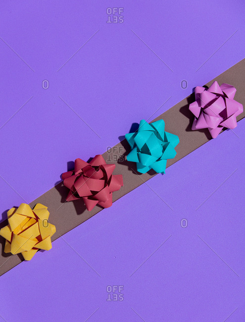 Overhead view of holiday bows on purple background