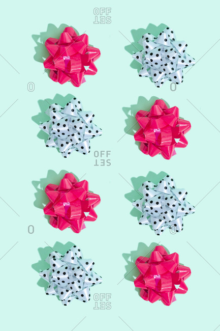 Eight gift bows arranged in a pattern on mint green background