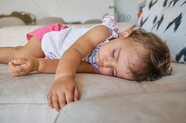 Little girl sleeping on the couch of a house