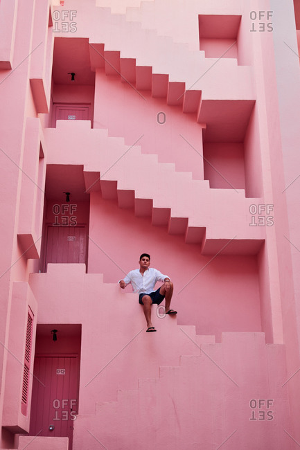 Calp, Valencian Community, Spain - August 6, 2020: Young Latin man in the "Muralla Roja" in Calpe, Spain