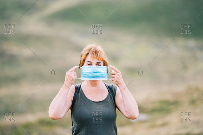 Traveling woman putting a medical face mask on her face