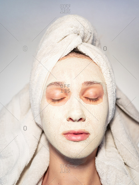 Closeup portrait woman facial mud mask hair wrapped in towel
