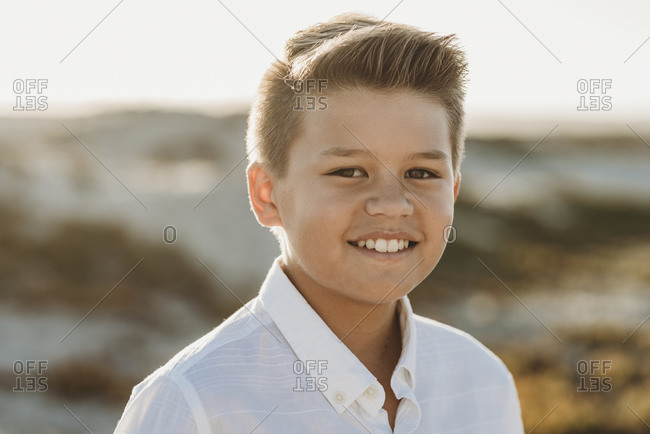 Smiling clean-cut preteen boy wearing button-down white shirt