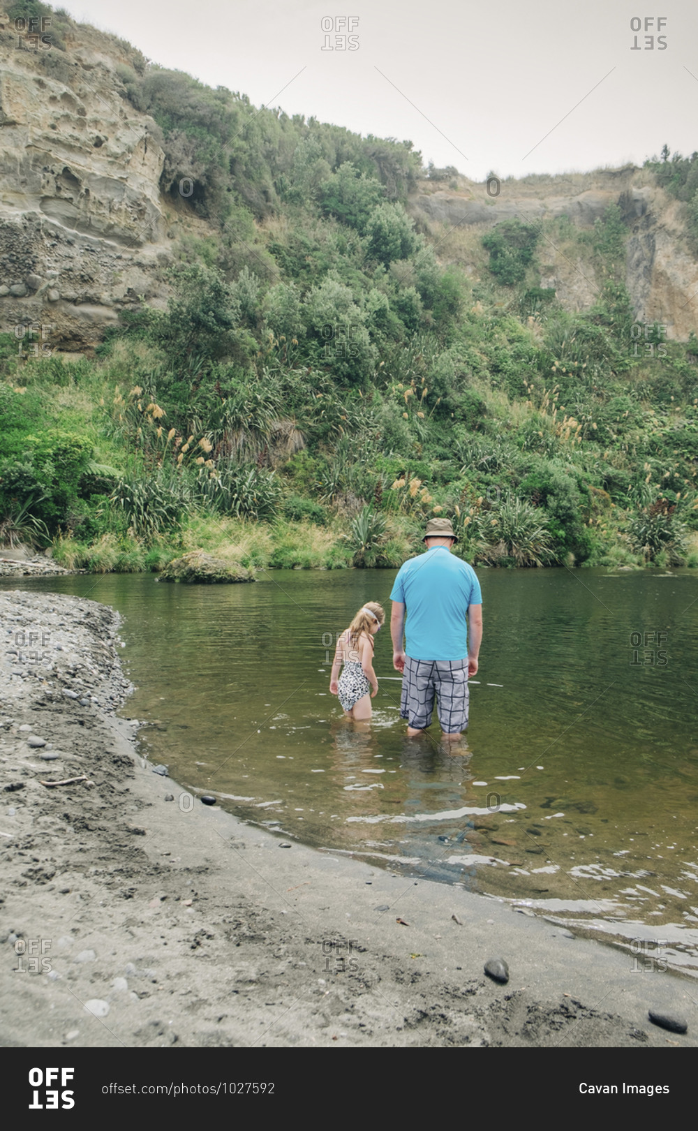 Father and daughter playing in the water at a scenic river spot