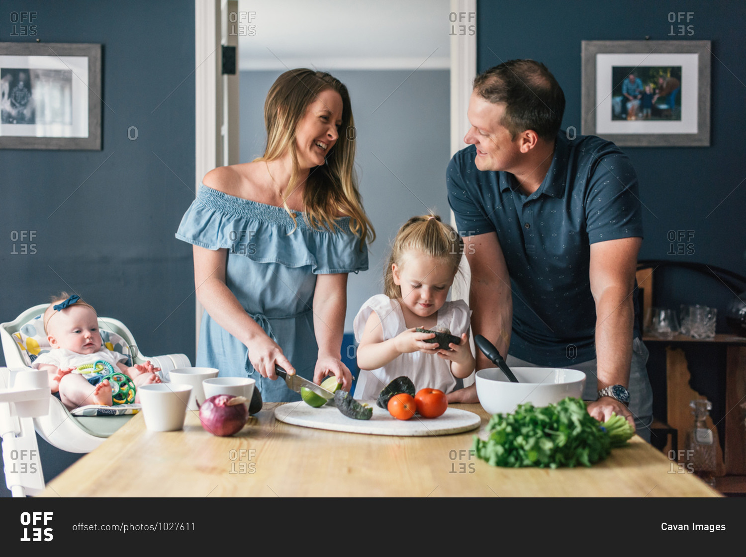 Family with young children laughing while making healthy food