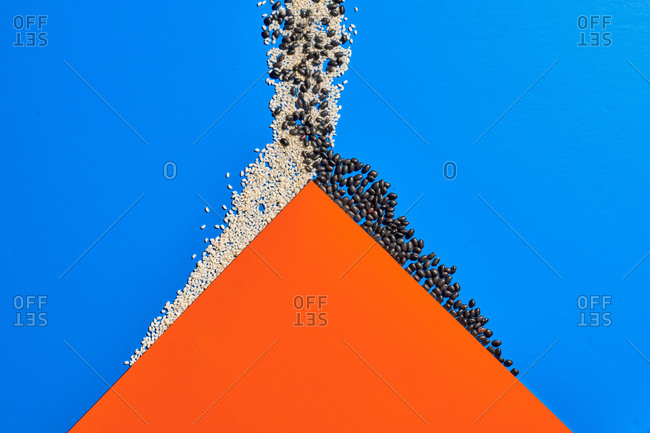 Top view of orange paper in shape of mountain placed on blue background with white and black grain