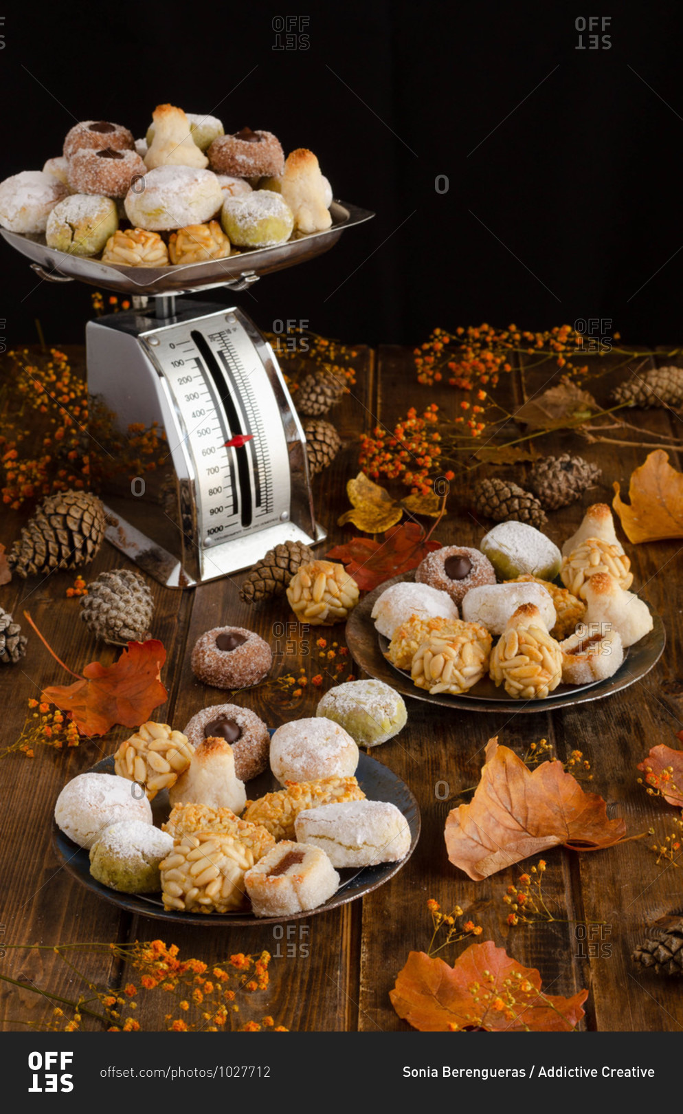 Various delicious Panellets arranged on wooden table with autumn leaves and cones prepared for celebration of All Saints Day in Spain