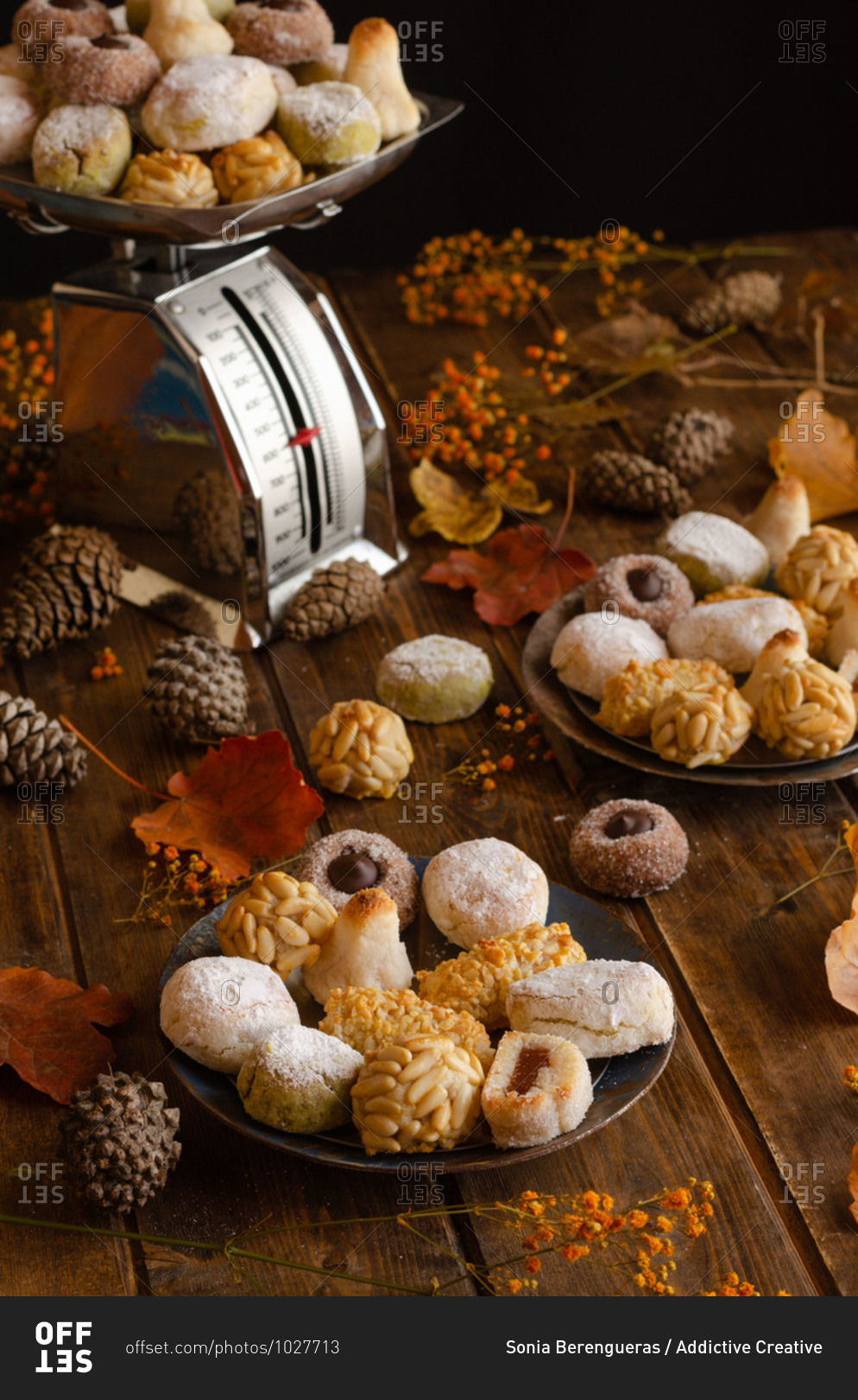 Various delicious Panellets arranged on wooden table with autumn leaves and cones prepared for celebration of All Saints Day in Spain
