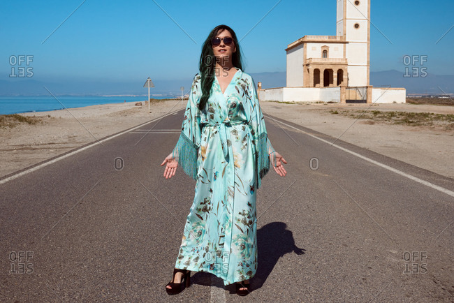 Brunette posing in a blue kimono in the middle of the road.