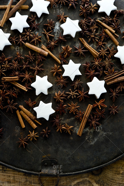 Cinnamon star cookies- cinnamon sticks and star anise on rustic baking sheet