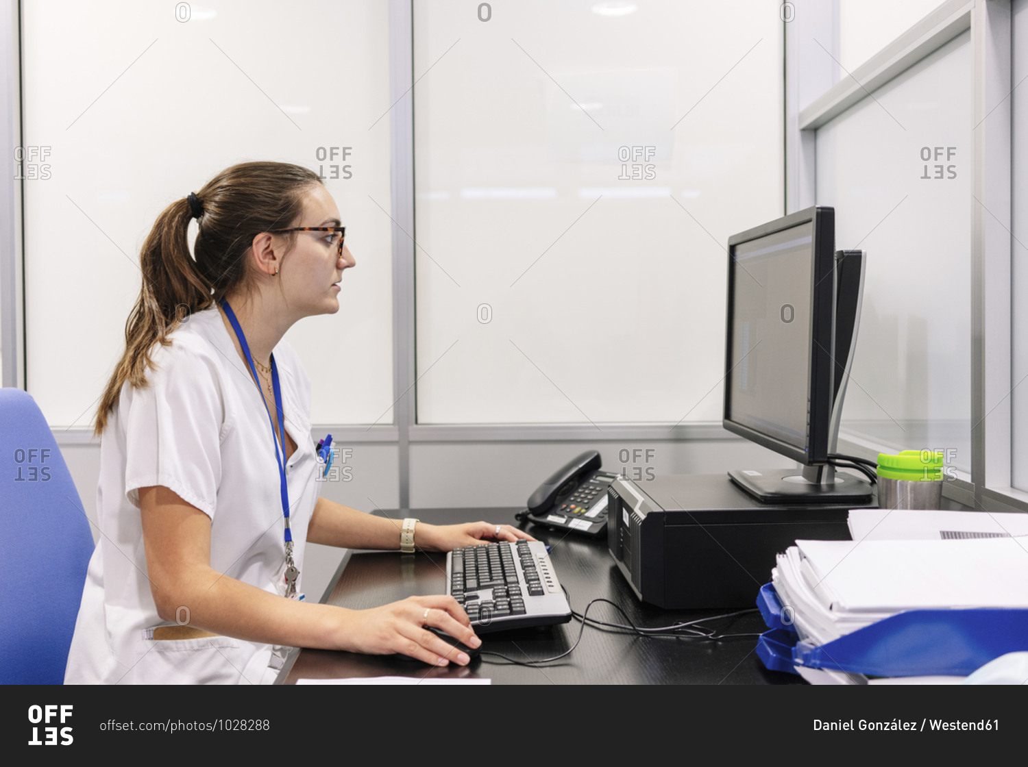 Female pharmacist using computer on desk in pharmacy