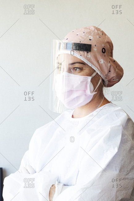 Orthodontist in protective suit standing with arms crossed at office