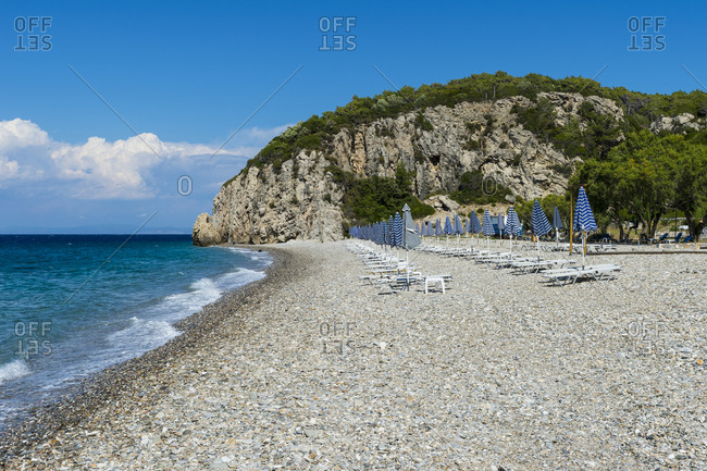 Greece- North Aegean- Rows of beach umbrellas and empty deck chairs on Tsambou beach in summer