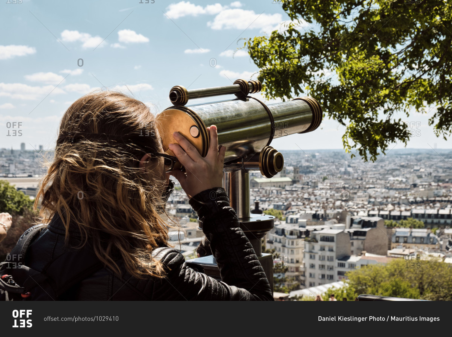 Europe, France, Paris, Montmartre, Sacre Coeur, Woman looking through telescope at Paris,