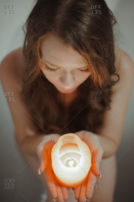 Woman sitting in bathtub and is relaxing with lights and candle,