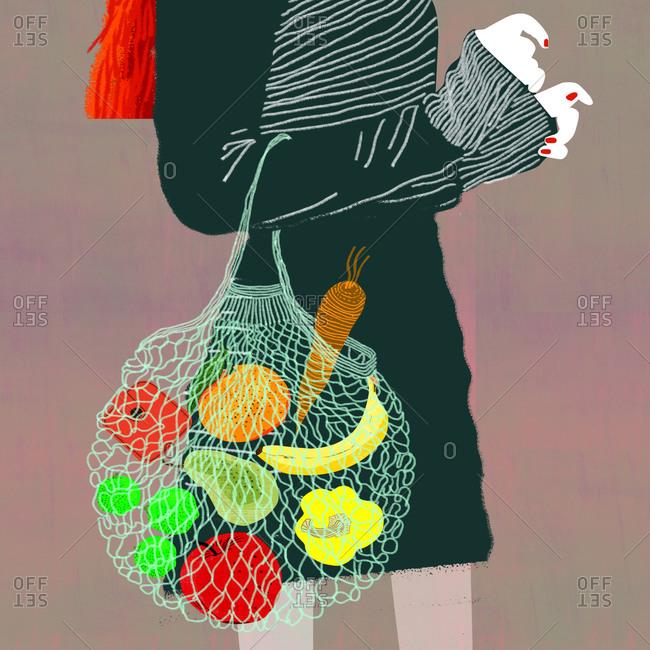 Side view of a slim woman with reusable shopping bag with vegetables and fruit