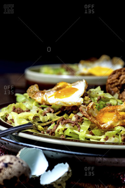 Pan dish, pointed cabbage, minced beef, fried egg from quail eggs