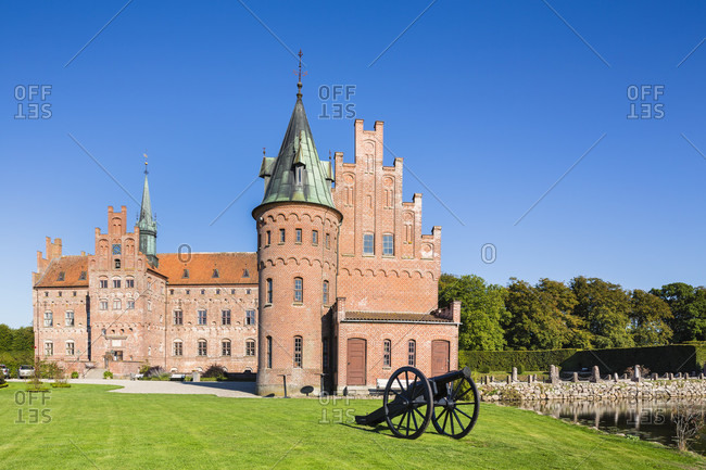 Egeskov castle (moated castle)and a historic cannon on the lawn, funen island