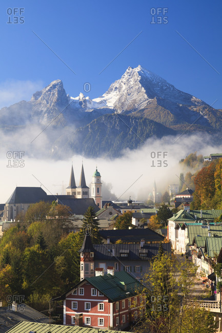 Low clouds at berchtesgaden town skyline with church and watzmann moutain in the background, autumn,
