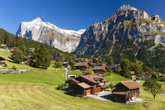 Chalets in front of mount wetterhorn, bernese alps, unesco world heritage site