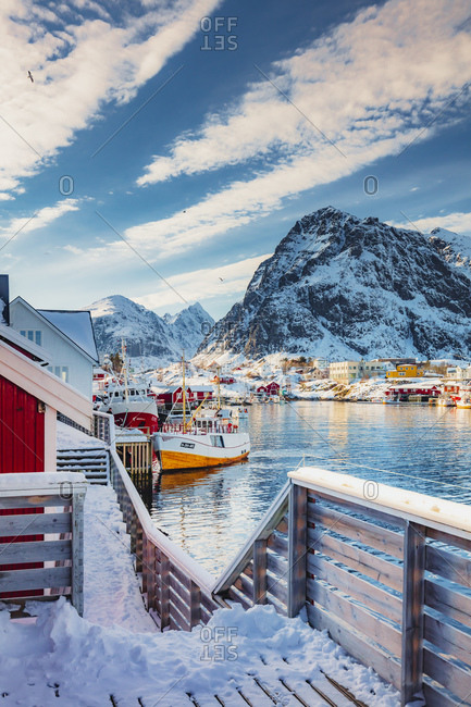 Traditional village of Reine in Lofoten Islands with fishermen houses on a winter morning with the mountains in the background covered with snow