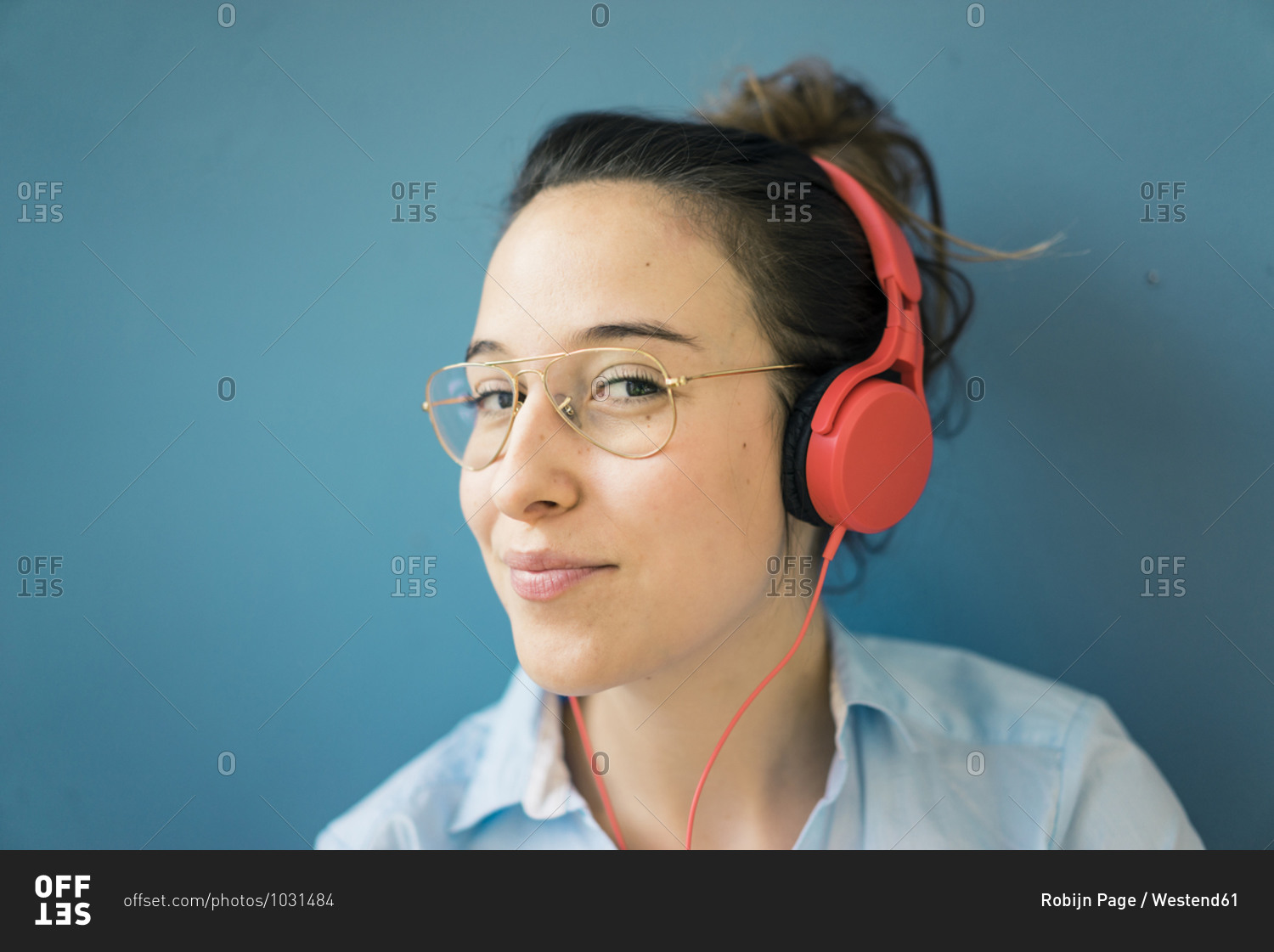 Portrait of smirking woman listening music with headphones