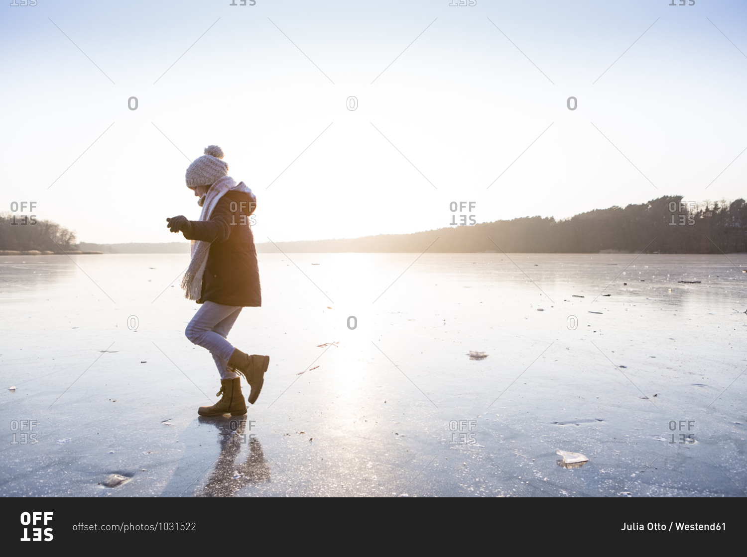 Germany- Brandenburg- Lake Straussee- girl walking on frozen lake