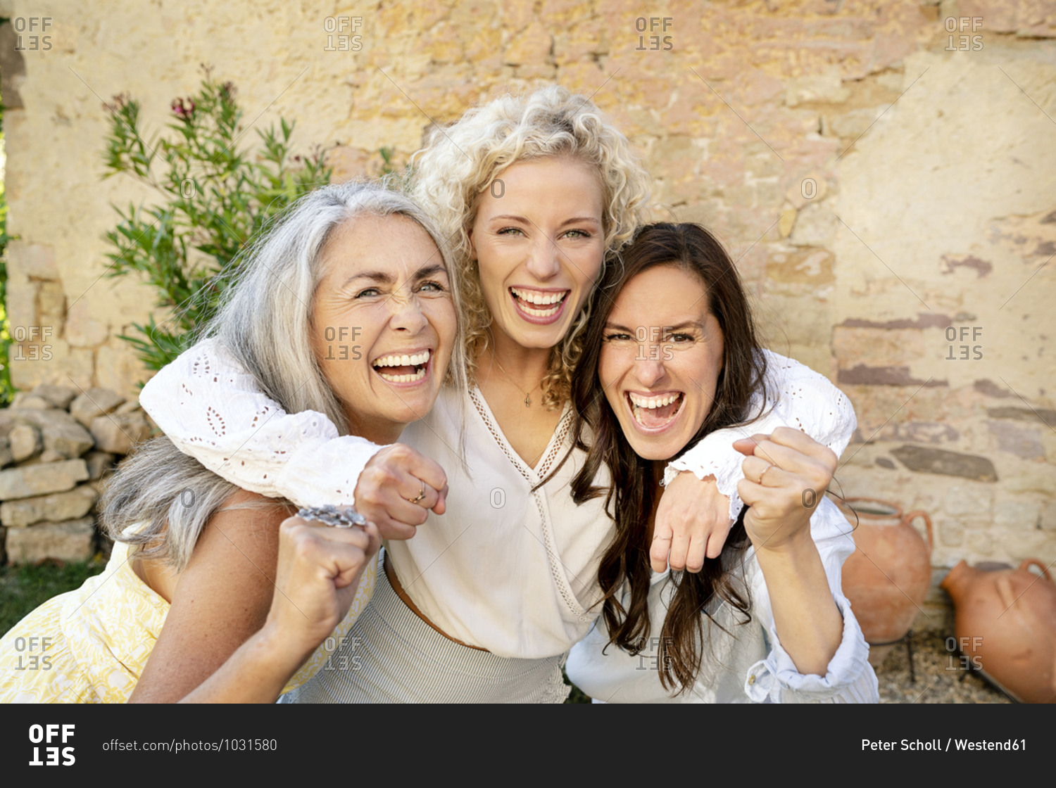 Portrait of three excited women of different age embracing and cheering