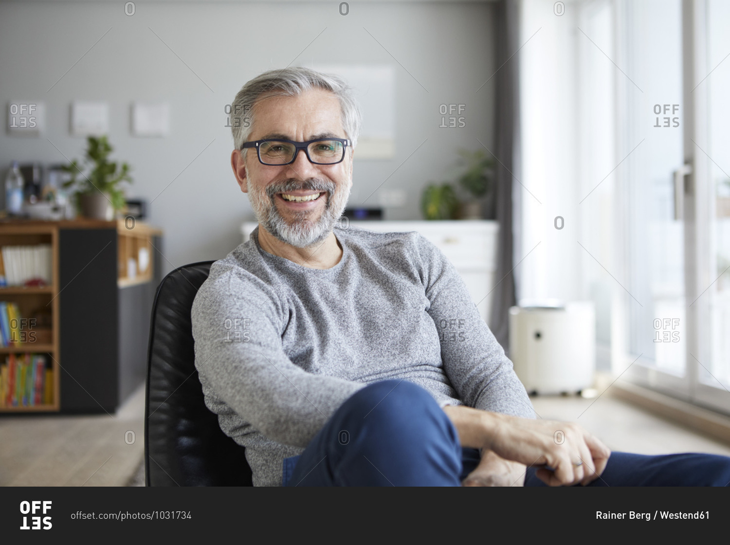 Portrait of content mature man in his living room