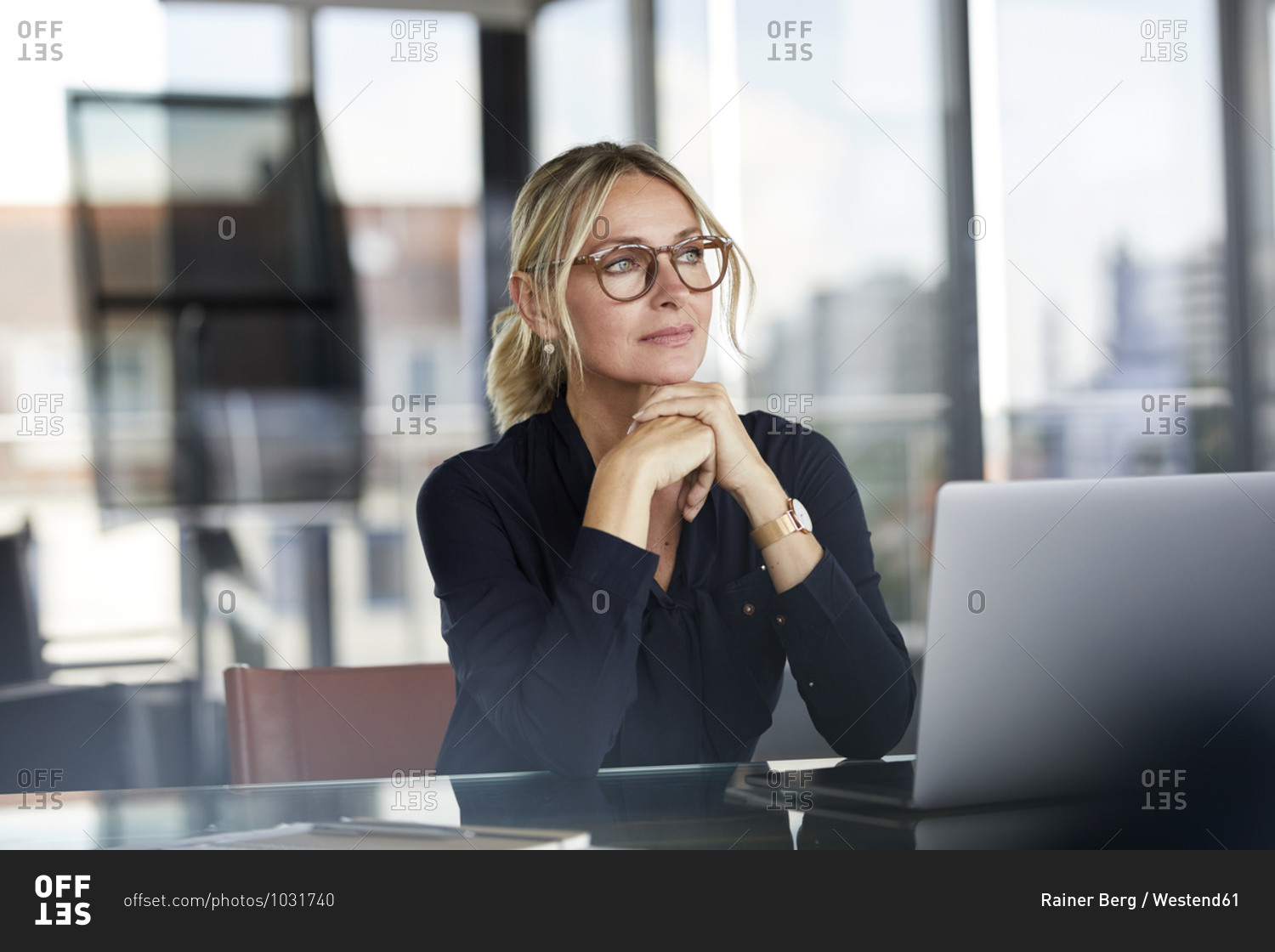 Businesswoman sitting at desk- thinking