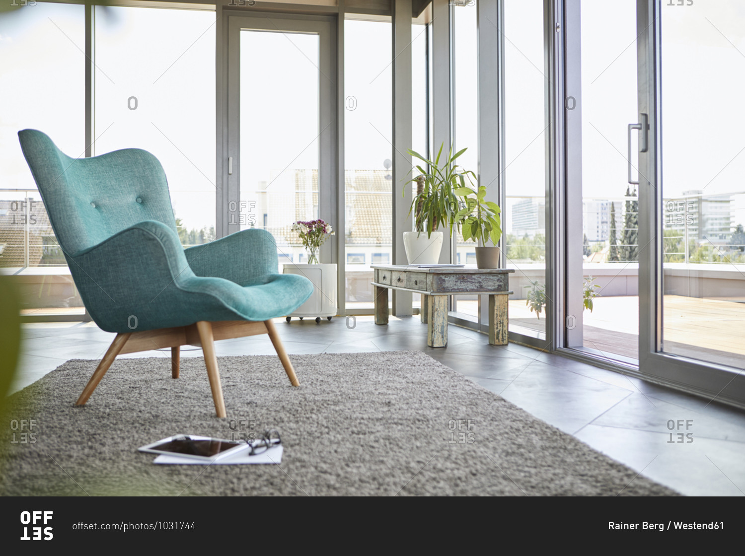 Home interior with armchair- tablet and view on roof terrace