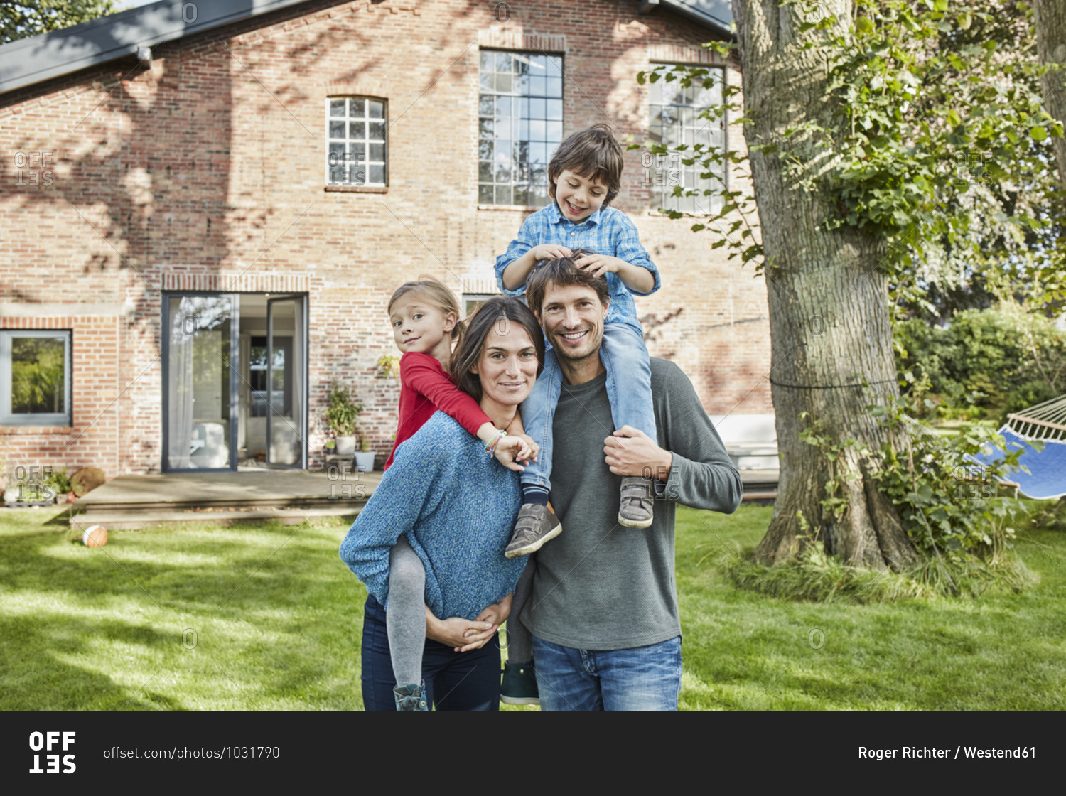 Portrait of happy family in garden of their home