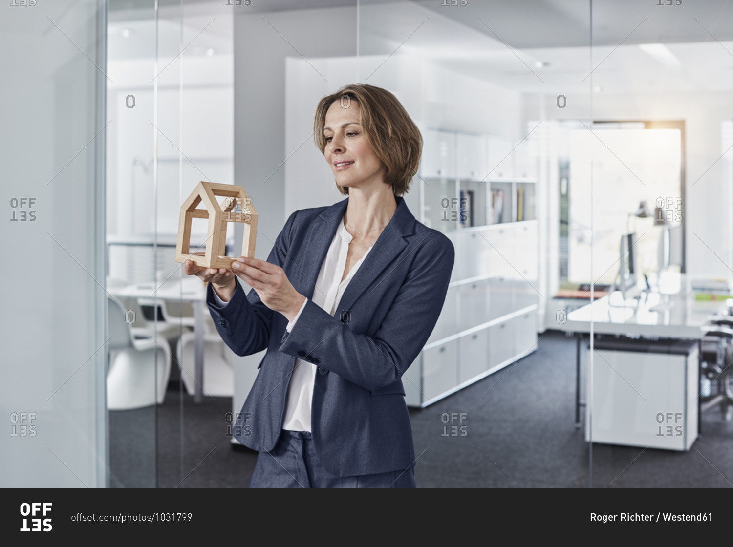 Smiling businesswoman looking at architectural model in office