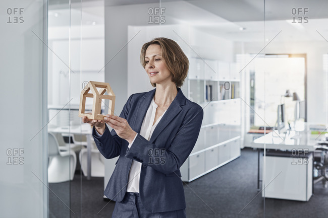 Smiling businesswoman looking at architectural model in office