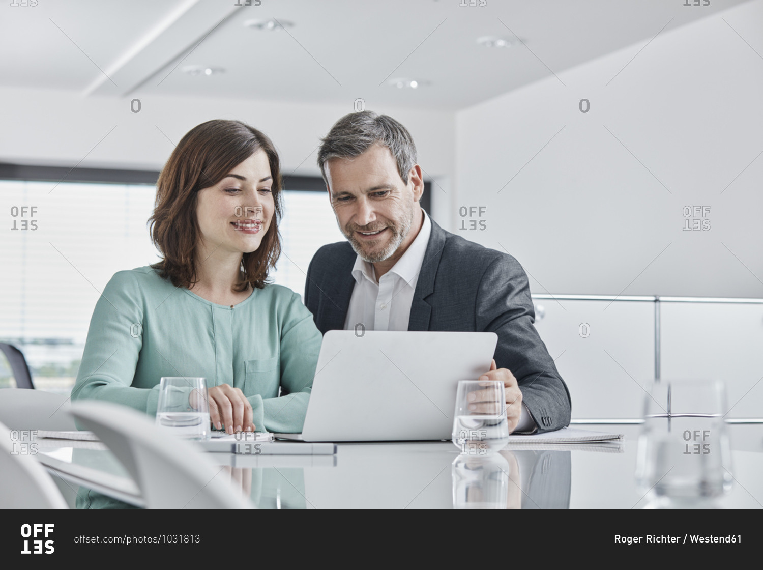Businessman and businesswoman having a meeting in office with laptop