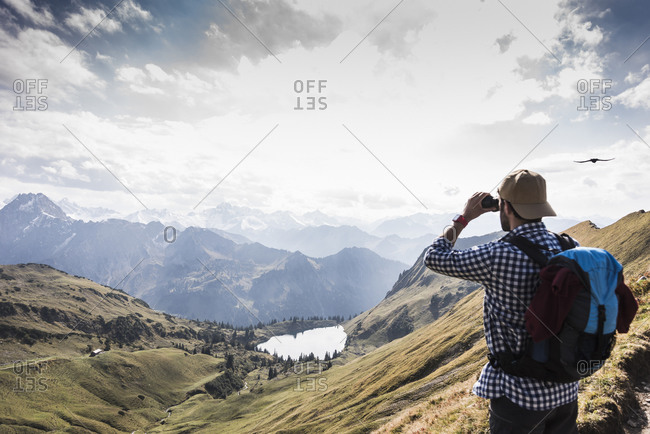 Germany- Bavaria- Oberstdorf- hiker with binoculars in alpine scenery