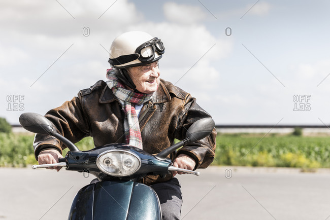 Active senior man speeding on his motor scooter