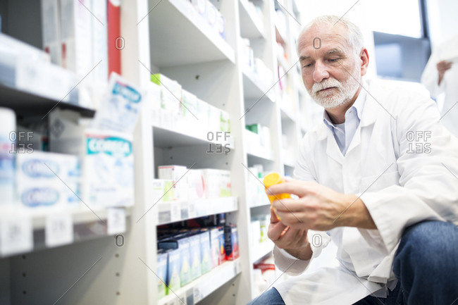 Pharmacist examining pill box in pharmacy