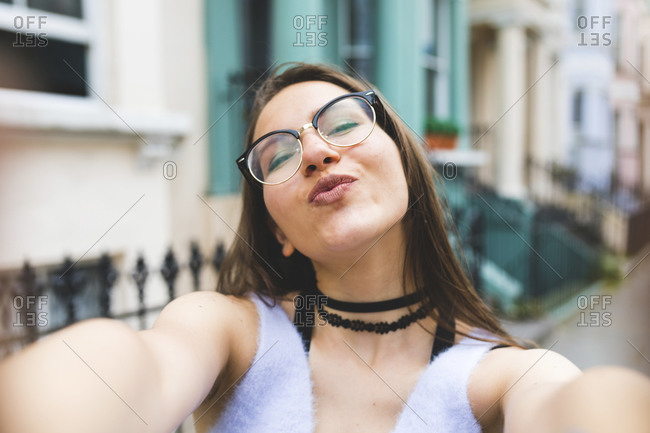 Happy teenage girl in the city taking a selfie