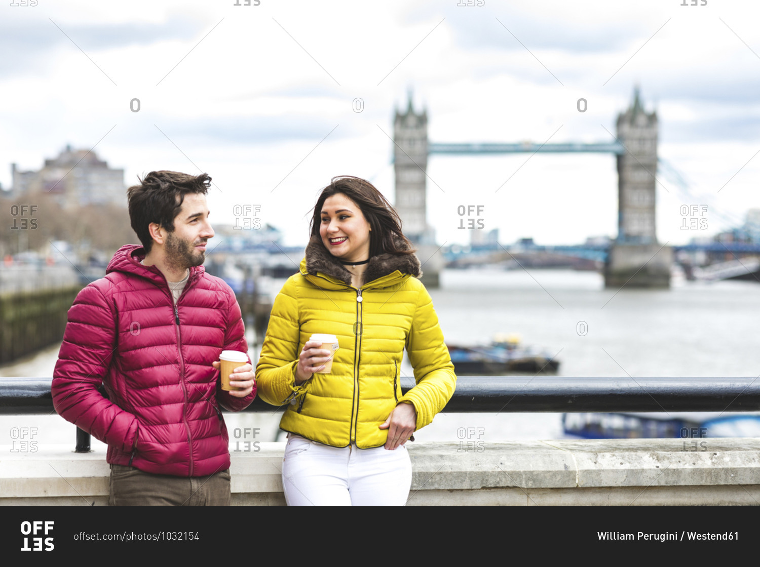 UK- London- couple with coffee to go standing on bridge over the Thames