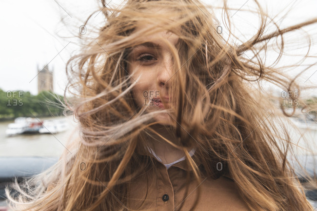 Portrait of smiling young woman with windswept hair- London- UK