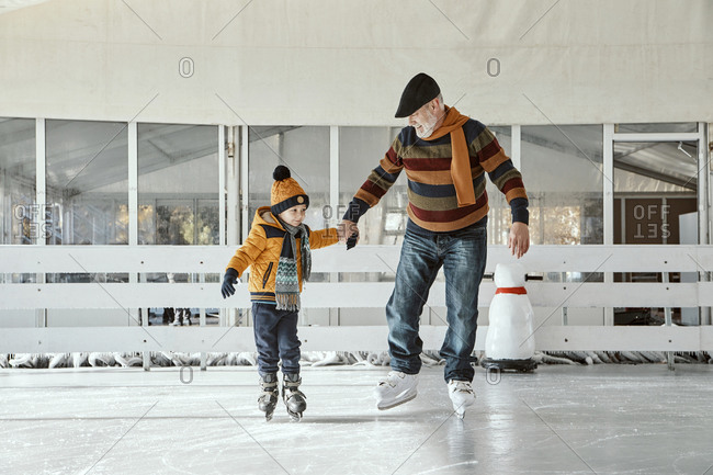 Grandfather and grandson on the ice rink- ice skating