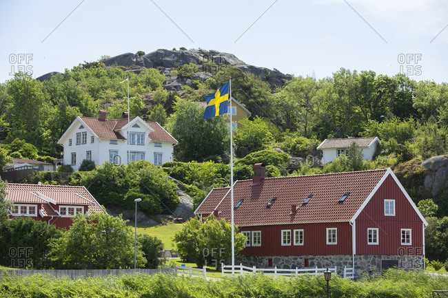 Swedish flag in front of wooden house